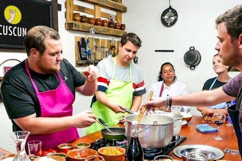 Participantes preparan comida en una clase de cocina. 5