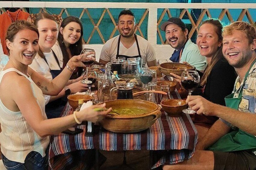 Un grupo de personas sentadas alrededor de una mesa con comida y bebidas. 2