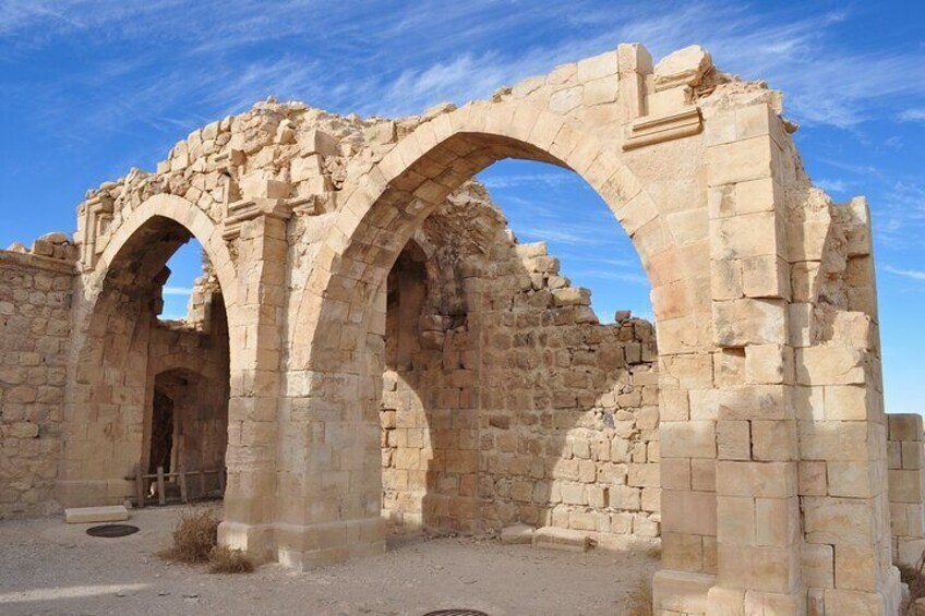 Ancient stone ruins with large arches and a clear blue sky. 1