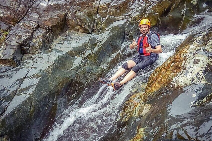 Eine Person sitzt auf einem Felsen neben einem Wasserfall. 3