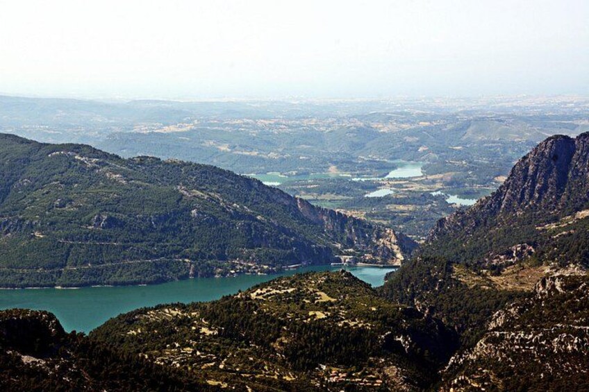 Un paisaje montañoso con un lago y una vista distante de un pueblo. 2