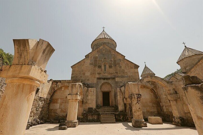 An ancient stone church with a central dome and smaller domes on either side. 2