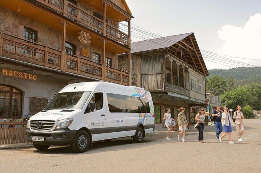 A white van parked in front of a wooden building with balconies and a sign that reads "MAESTRO". 4