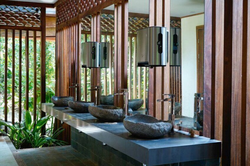 A modern bathroom with stone sinks and wooden paneling. 3