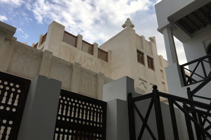 A building with a white facade, a black gate, and a staircase. 5