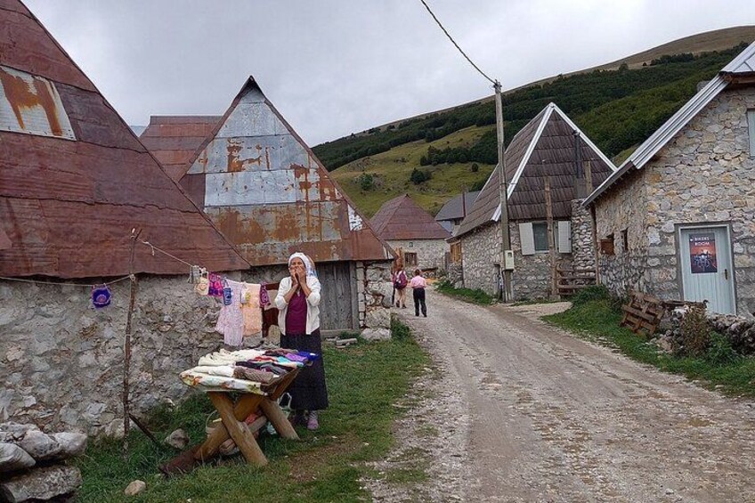 Un pueblo rural con edificios de piedra y un camino de tierra. 3