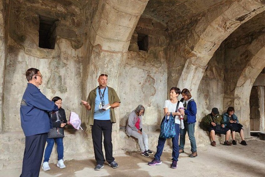 A group of people in an ancient stone structure with arches. 3
