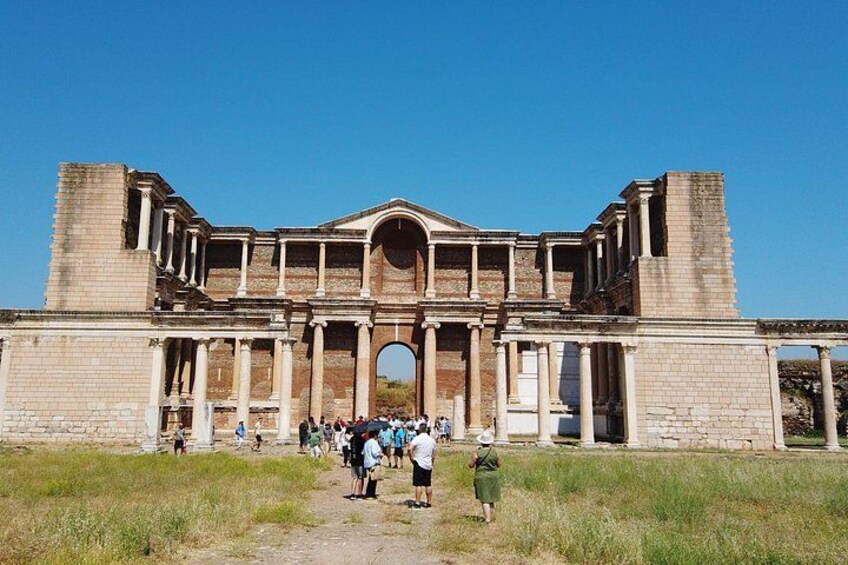 An ancient Roman amphitheater with columns and an archway. 1