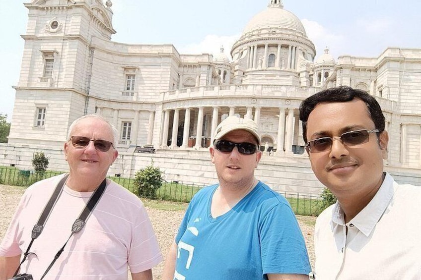Three people standing in front of a large, classical building with columns and a dome. 2