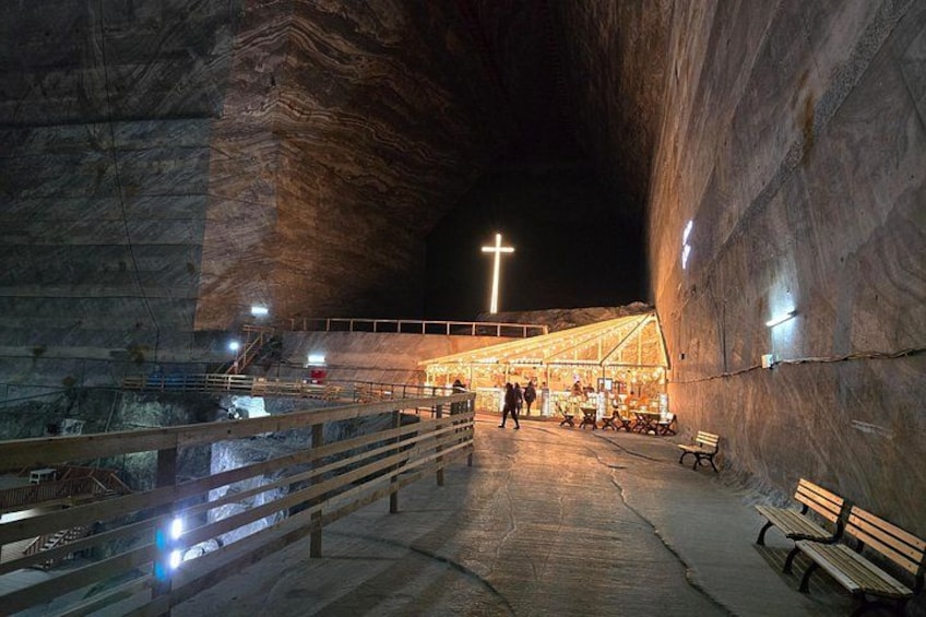 Una estructura que recuerda a una cueva, con un altar cruciforme, bancos y un pasillo. 2