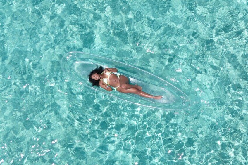 Una persona flota sobre un círculo inflable transparente en una piscina. 3