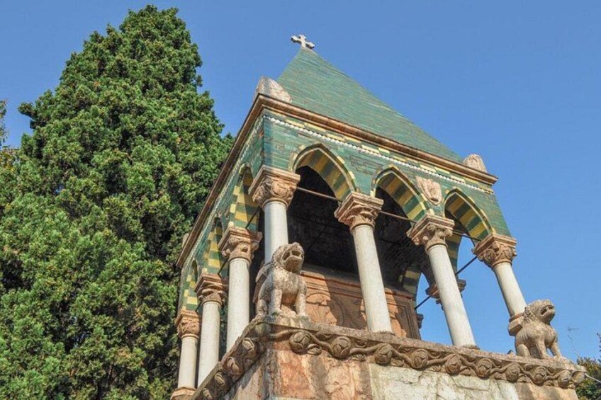 Un edificio con tetto verde, colonne e statue di leoni. 5