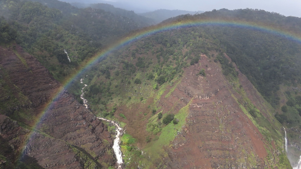 A lush green valley with a river and a waterfall. 3