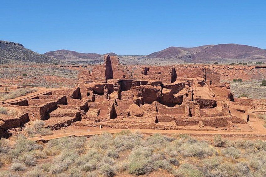 Ancient ruins with red sandstone structures in a desert landscape. 1
