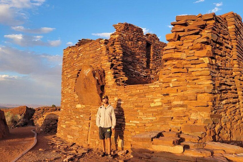 A person standing in front of a large, ancient brick structure with a circular opening. 2