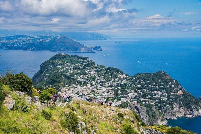 A coastal town with buildings on a hillside, a mountain in the background, and the sea. 5
