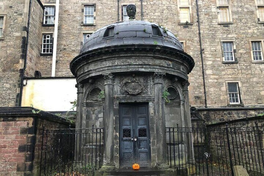 Un edificio storico in pietra con una cupola e una porta nera. 2