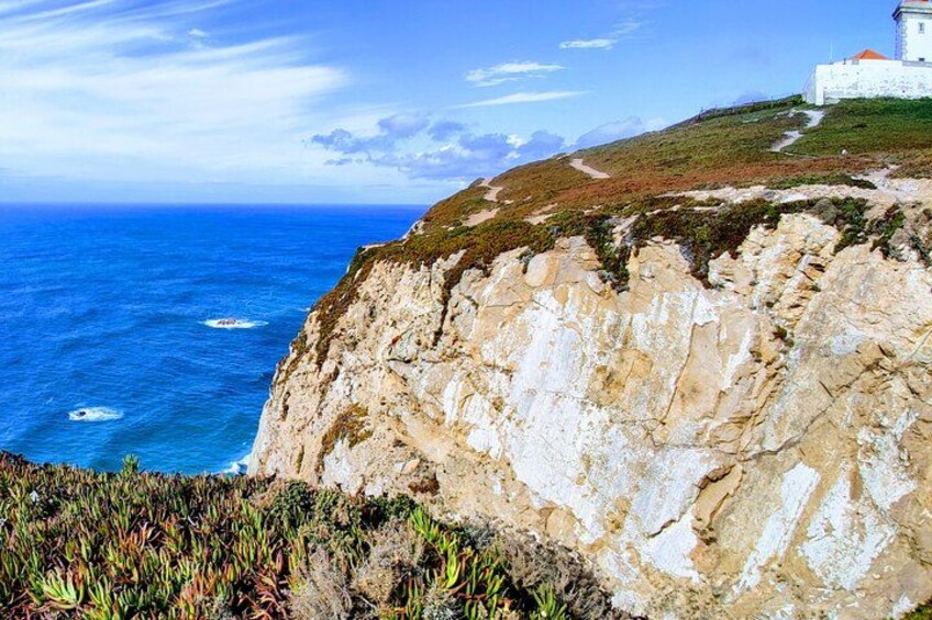 Une falaise côtière surmontée d’un phare, d’où l’on a une vue sur la mer. 4