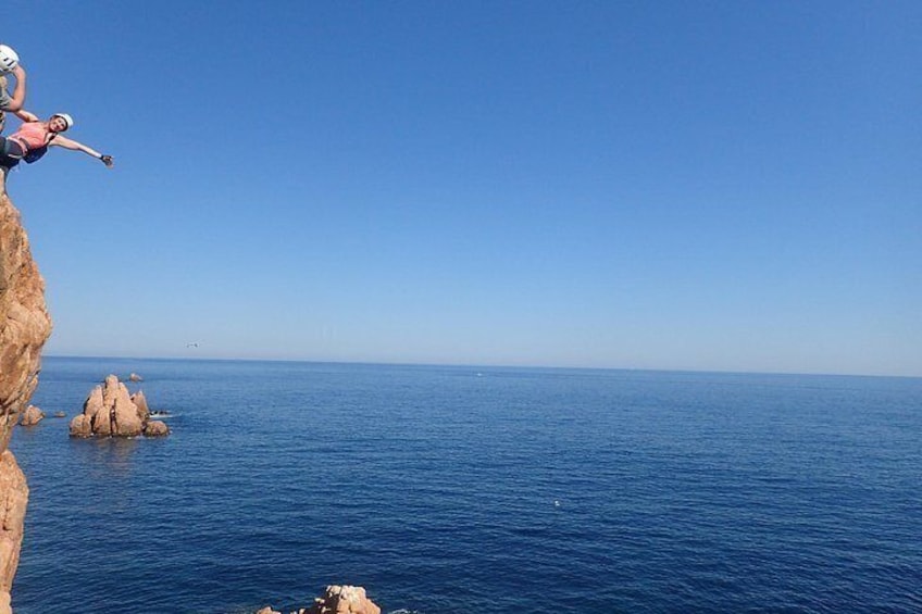 Eine Person springt von einer Klippe ins Meer. 3