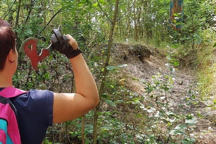 A person hiking in a forested area with dense vegetation and a dirt path. 2