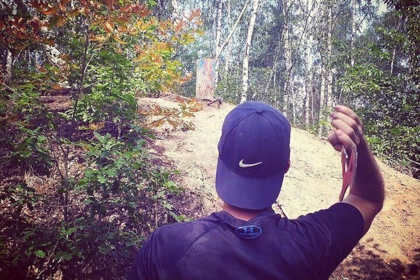 En person som vandrar på en stig i skogen, omgiven av träd. 4