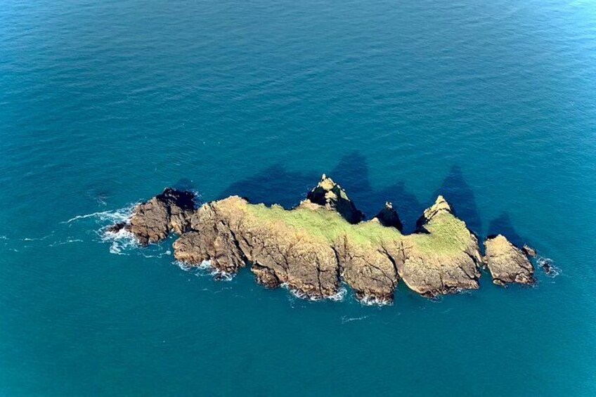 An aerial view of a rocky coastline with clear blue waters. 3