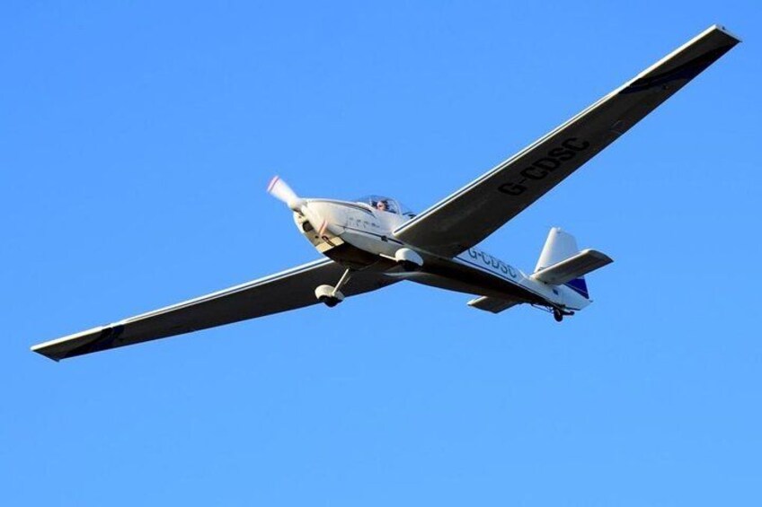 A small aircraft with registration G-CDSC flying against a clear blue sky. 2