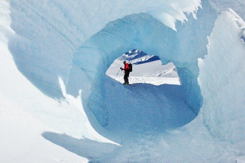 A person standing inside a large ice cave. 3