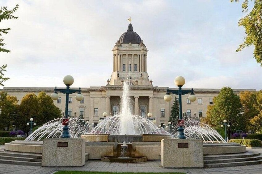 A large building with a dome and a fountain in front. 4