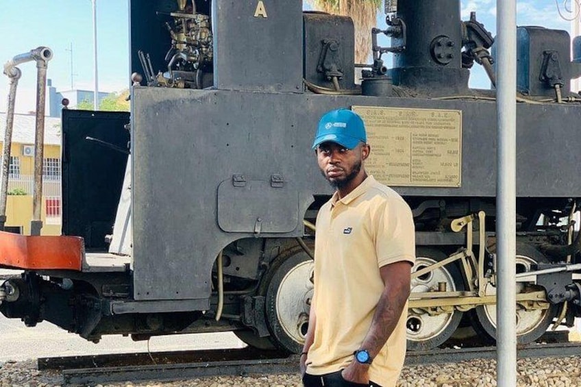 A man standing in front of a train engine. 2