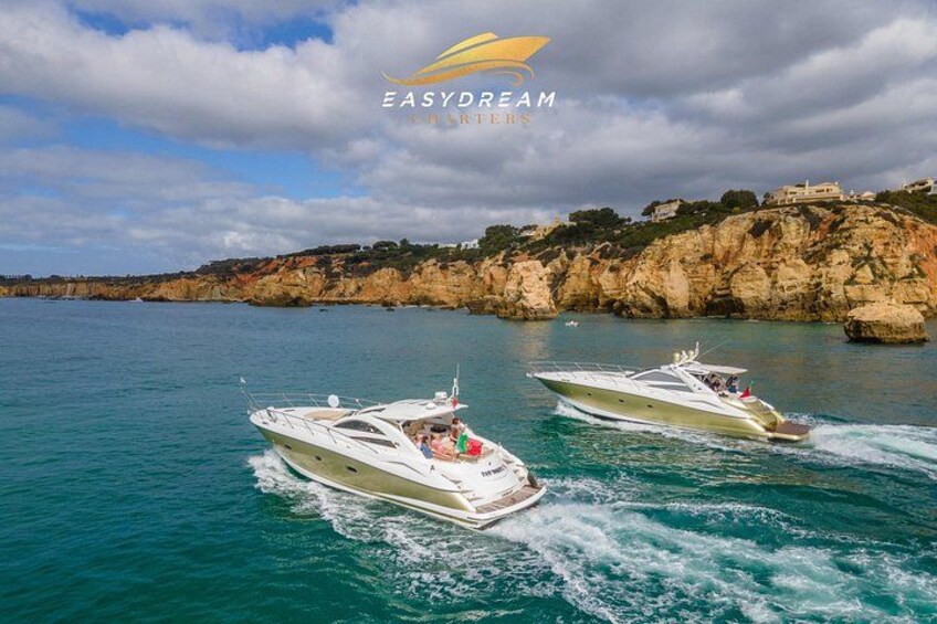 Two speedboats on a turquoise sea with rocky cliffs in the background. 1