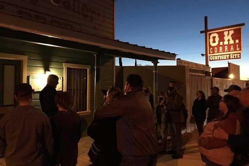 A group of people gathered outside a building with a sign reading 'O.K. CORRAL'. 2