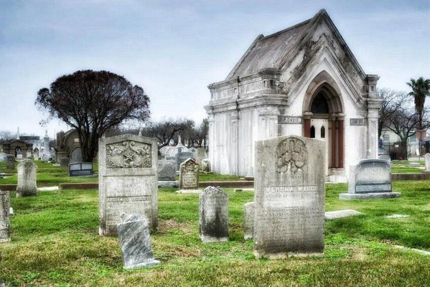 A cemetery with gravestones and a Gothic-style chapel. 1