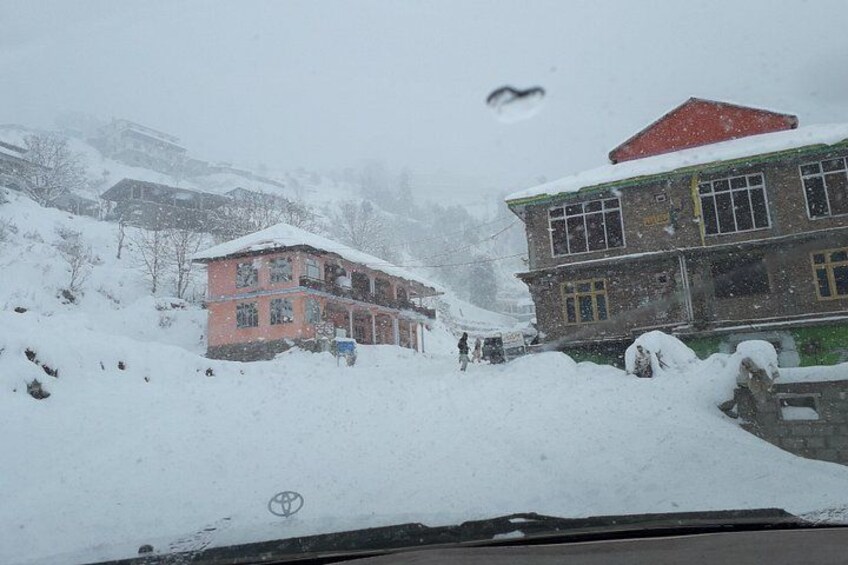 Un paisaje nevado con edificios y una carretera. 3
