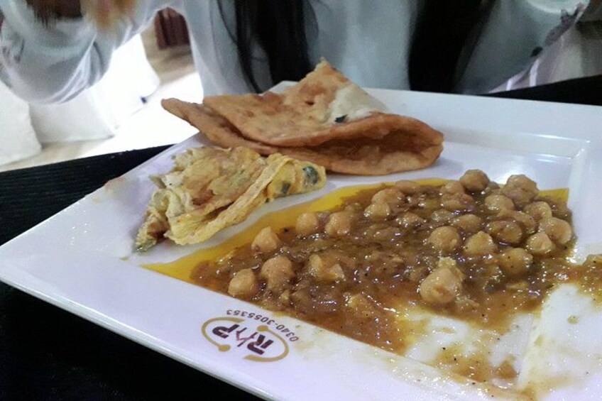 Un plato de comida con garbanzos y pan plano. 4