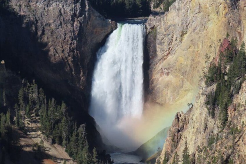 A waterfall cascading down a rocky cliff surrounded by trees. 4