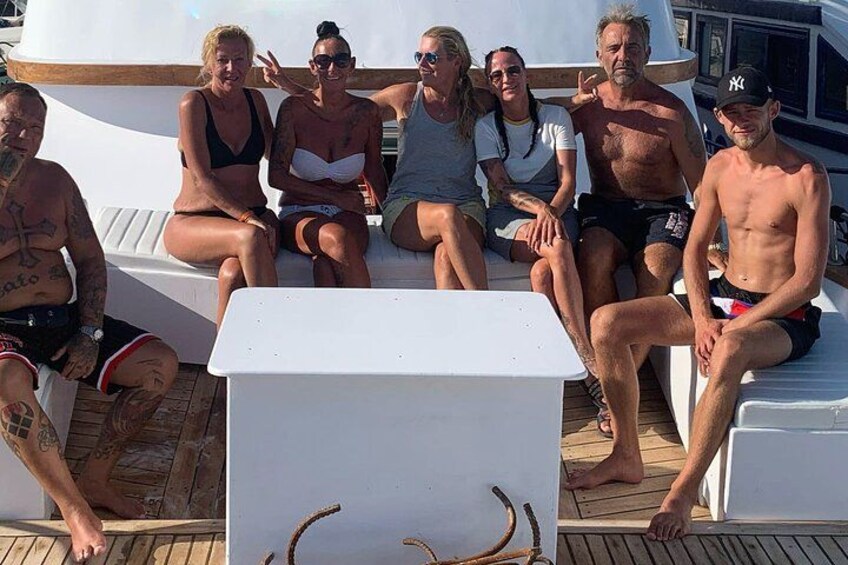 A group of people sitting on a boat deck. 4