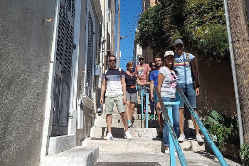 Un grupo de personas sube por una escalera estrecha en un callejón angosto, flanqueado por edificios. 4