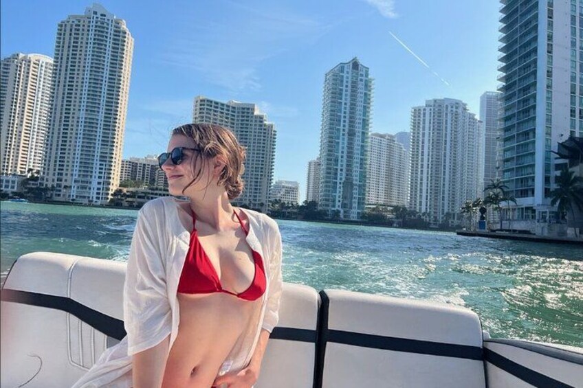 A person on a boat with a city skyline in the background. 2