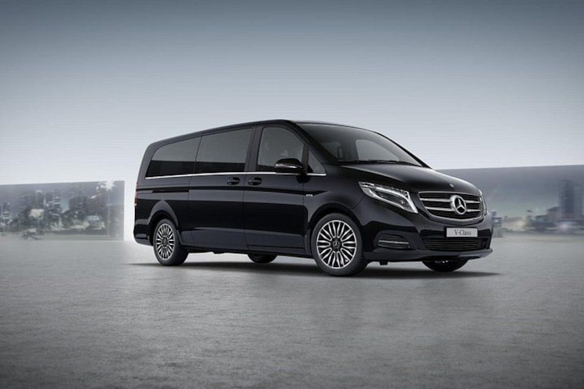 Un furgone Mercedes-Benz V-Class nero parcheggiato su una superficie piana, con uno skyline urbano sullo sfondo. 2