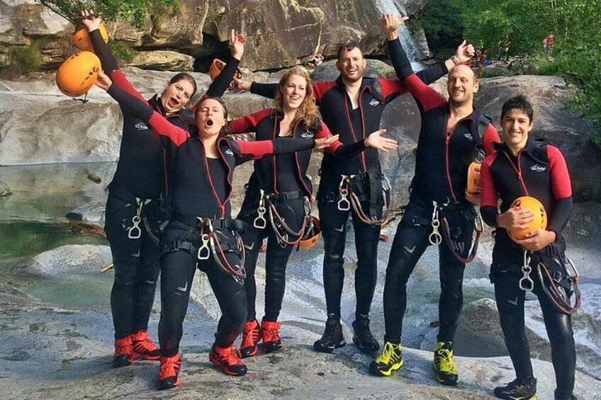 A group of people in wetsuits with scuba gear, standing on a rocky shore. 2
