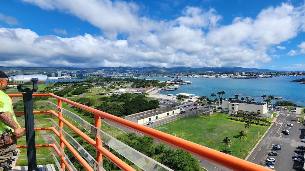 A panoramic view of a coastal city with a marina, green spaces, and a clear blue sky. 2