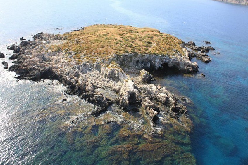 Una isla rocosa rodeada de aguas azules y transparentes. 3