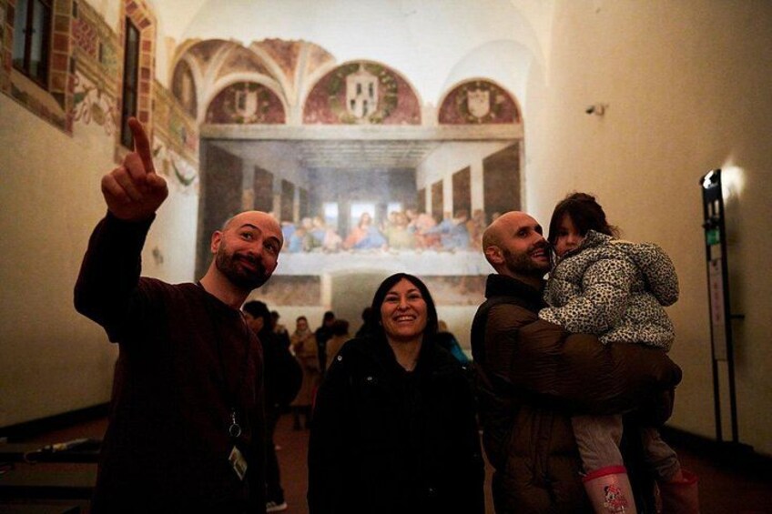 A group of people in a corridor with a famous painting in the background. 3