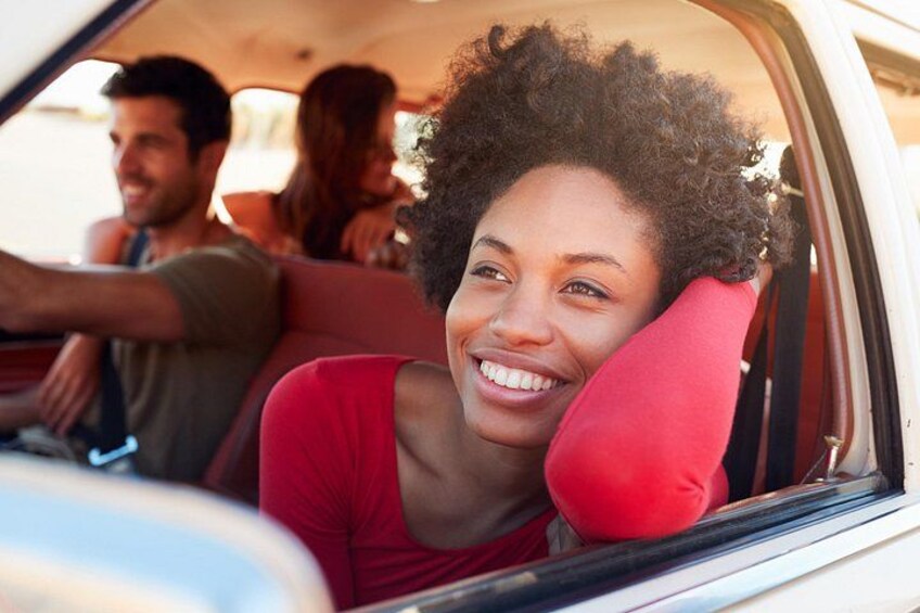 A person sitting in a car with a red pillow. 4