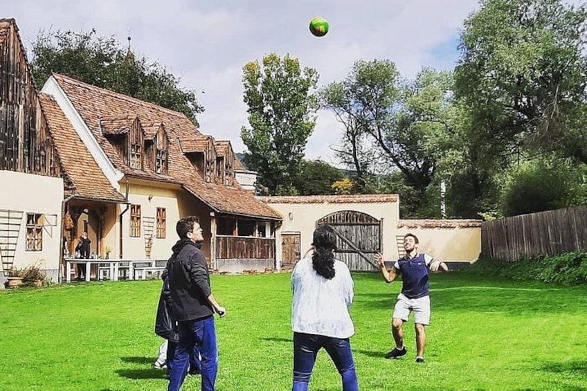 A group of people playing with a ball in a grassy yard with a house in the background. 4