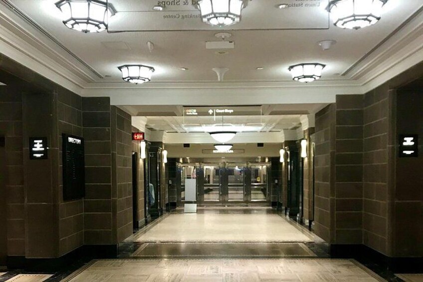 En hotellkorridor med skyltar som visar vägen, en receptionsdisk och ett välpolerat golv. 5