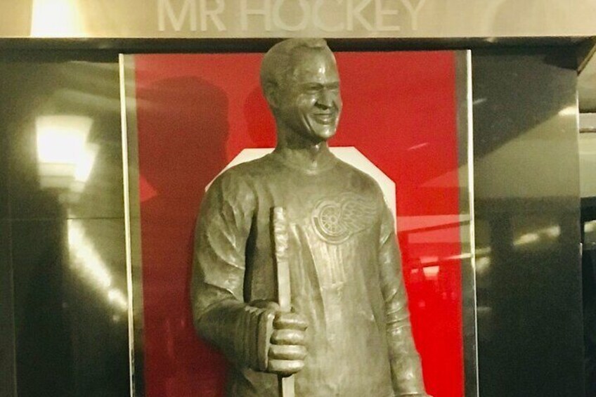 A statue of a hockey player holding a hockey stick, with a red background and the text "MR HOCKEY" above. 1