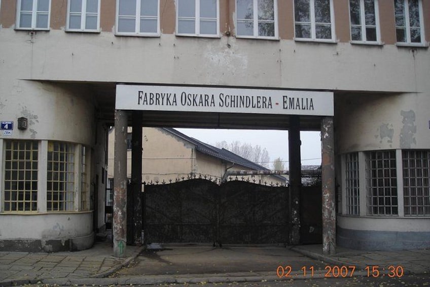 A building entrance with a sign reading 'FABRYKA OSKARA SCHINDLERA - EMALIA'. 3