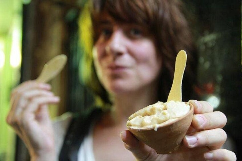 A person holding a bowl of food with a spoon. 1